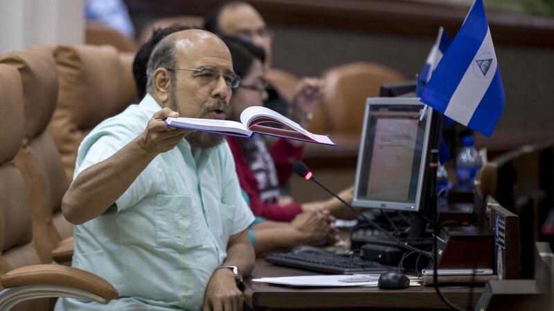Sandinista deputy Edwin Castro holds a book of the Nicaraguan constitution during an extraordinary session in parliament for the approval of the the Law for the Defence of the Rights of the People to Independence, Sovereignty and Self-Determination for Peace. Photograph: Jorge Torres/EPA