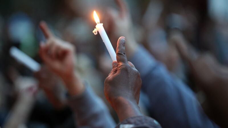 People attend a vigil to mark four weeks since the Grenfell Tower fire, at the memorial wall on Bramley Road, London. Photograph: Jonathan Brady/PA Wire