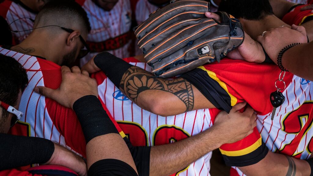 The Cayey Toritos pray before their home opener in Aibonito, Puerto Rico. Photograph: Dennis M Rivera Pichardo/The New York Times