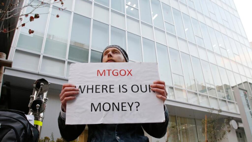 Kolin Burges, a cryptocurrency trader and former software engineer, holds a placard to protest against Mt Gox, in front of the building where the digital marketplace operator is housed in Tokyo. Photo: Reuters