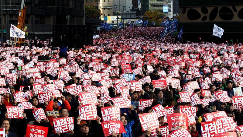 South Korean people shout slogans as they carry placards reading ‘Park Geun-Hye Out’, during a protest in Seoul, on Saturday. Photograph: EPA