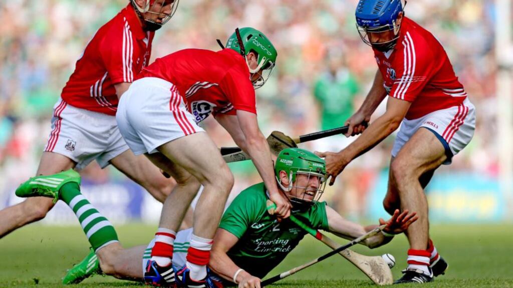 Cork’s Lorcan McLoughlin, Tom Kenny and Daniel Kearney tackle Seamus Hickey of Limerick. Photograph: Inpho