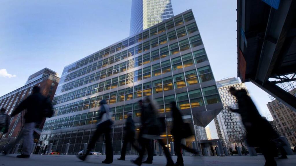 Pedestrians walk past Goldman Sachs Group headquarters in New York. Photographer: Jin Lee/Bloomberg