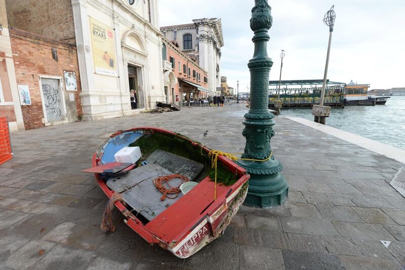 A boat is left stranded on the quayside following the high tide. Photograph: Andrea Merola/EPA