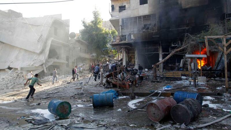 Residents run after, according to activists, two barrel bombs were dropped by forces loyal to Syria’s president Bashar Al-Assad in the Hellok neighbourhood of Aleppo yesterday. Photograph: Reuters