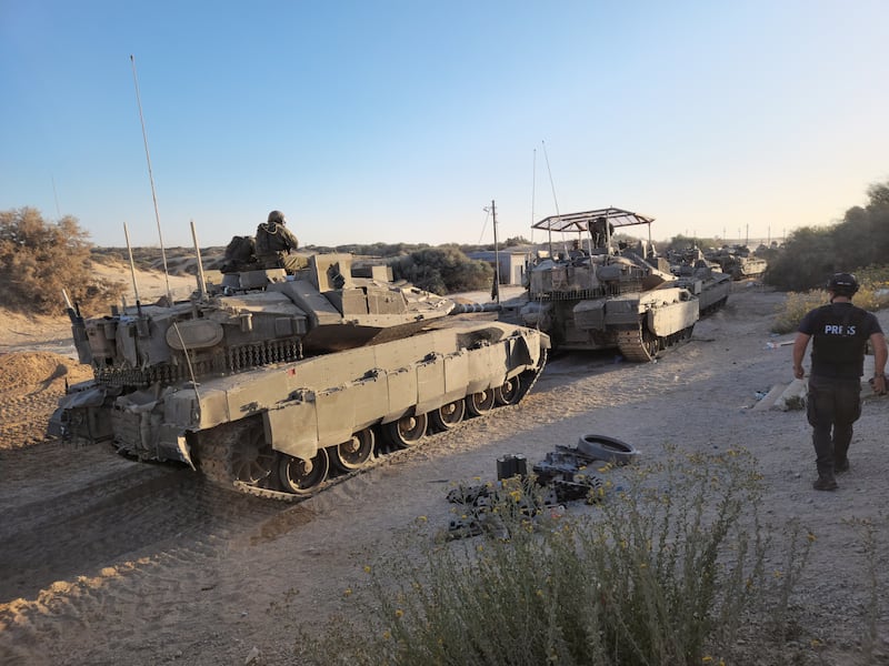 A member of the press walks by Israeli tanks in the Gaza Strip. Photograph: Ronen Bergman/The New York Times