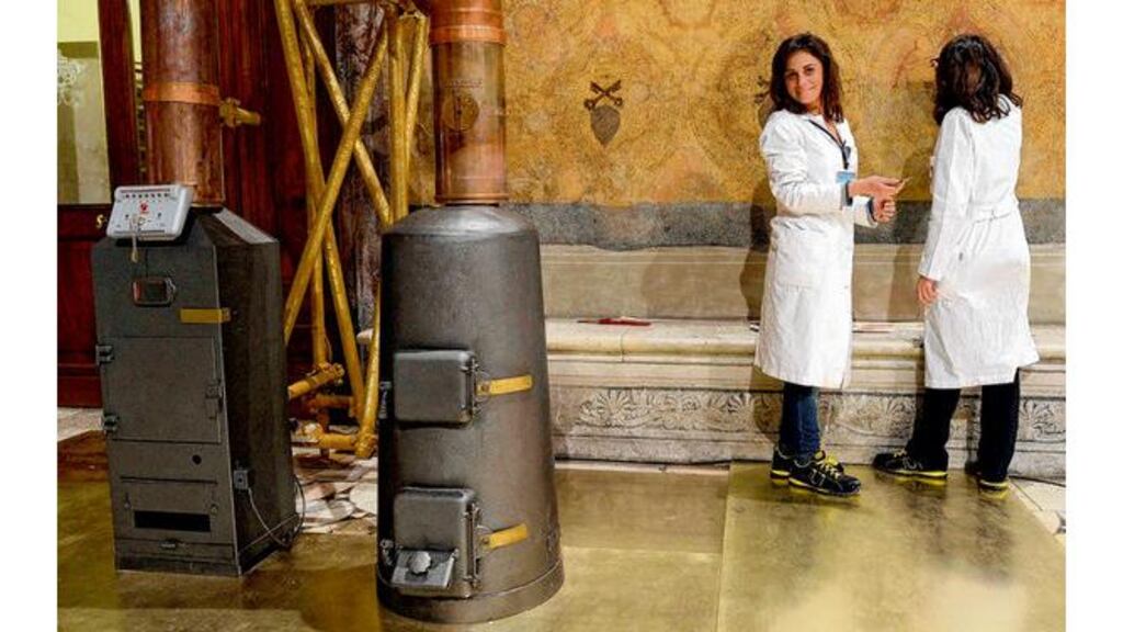 Workers stand next to stoves in the Sistine Chapel. photograph: reuters