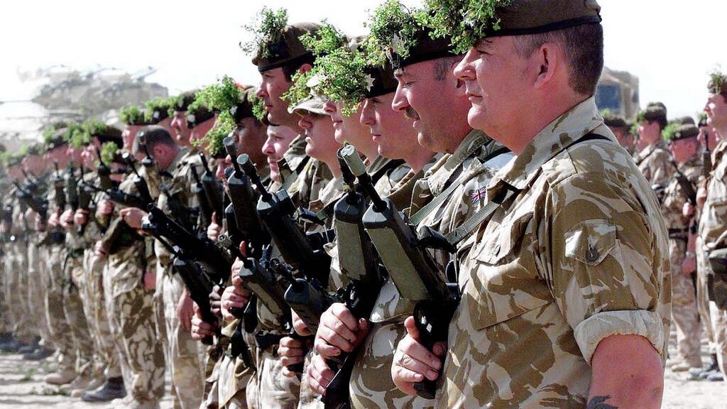 Gardaí Éireannach: Irish Guards wearing shamrocks on their berets take part in a parade on St Patrick’s Day in Kuwait, March 17, 2003. REUTERS/Mark Richards