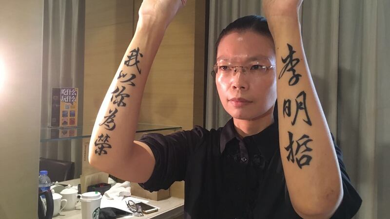 Lee Ching-yu, wife of detained NGO activist Lee Ming-cheh, displaying a tattoo whichs reads “I am proud of you, Lee Ming-cheh”, after attending his trial in Yueyang, in China’s central Hunan province. Photograph: whereislee.org/AFP/Getty Images