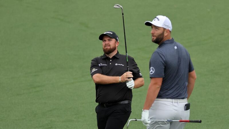Jon Rahm looks on as Shane Lowry chips on to the second green during a practice round on Wednesday. Photograph: Gregory Shamus/Getty Images