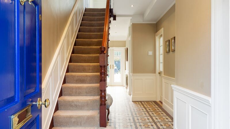 The front hall now has a mosaic-tiled floor, and the walls in the hall and upstairs landing are panelled.
