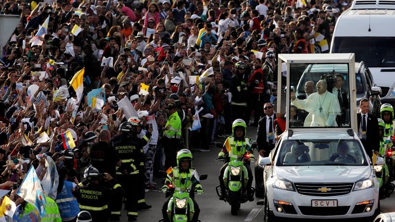 Pope Francis waves at the faithful as he travels in the popemobile through Bogotá, Colombia, on Wednesday. Photograph: Federico Rios/Reuters