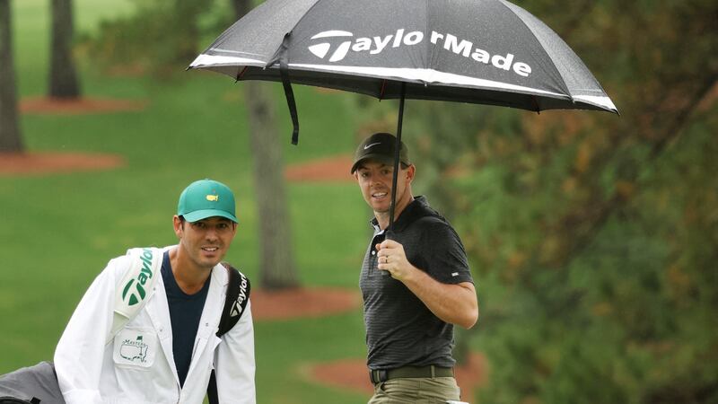 Rory McIlroy looks on from under an umbrella with caddie Harry Diamond on the seventh hole during a practice round prior to the Masters at Augusta National Golf Club. Photo: Rob Carr/Getty Images
