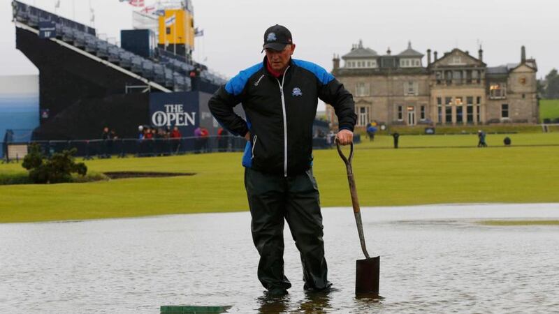 A member of the groundstaff stands in a puddle on the first fairway after torrential rain caused play to be suspended during the second round of the British Open. Photograph: Paul Childs/Reuters