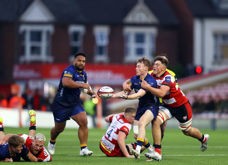 Fin Smith of Worcester Warriors feeds a pass as Alex Morgan of Gloucester Rugby tackles him. Photograph: Michael Steele/Getty