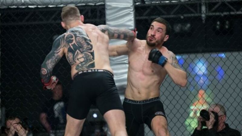 João Carvalho and his opponent Charlie Ward exchange blows during the Total Extreme Fighting event at the National Stadium in Dublin last April. The Portuguese fighter had signed a contract that guaranteed him  €350, with an extra €50 on top if he won. Photograph: Dave Fogarty