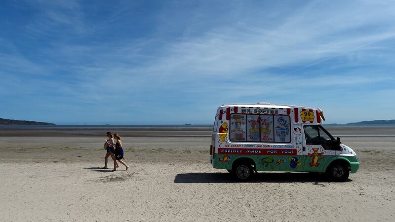 Women walk across the sand with ice creams, on a sunny day on Bull Island in Dublin. Photograph: Reuters