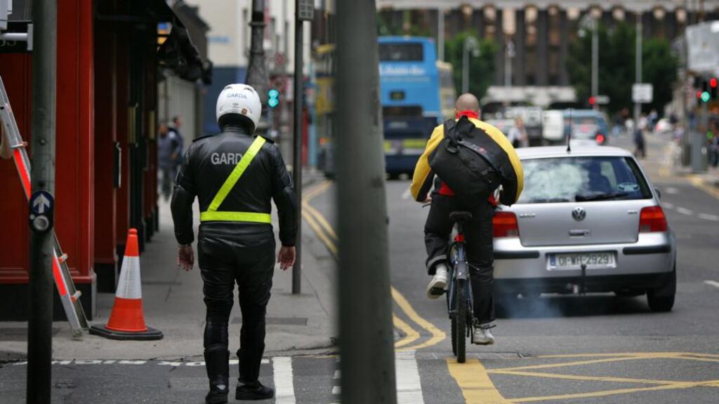 A garda watches a cyclist on a Dublin street. Minister for Transport Leo Varadkar has insisted the move is not about targeting cyclists but ensuring road safety. Photograph: Kate Geraghty