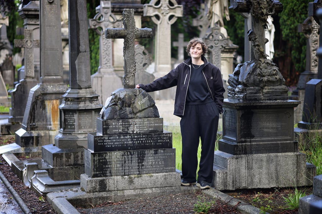 Tour guide Anna Collins stands beside the grave of Madeleine ffrench-Mullen in Glasnevin Cemetery. Photograph: Dara Mac Dónaill