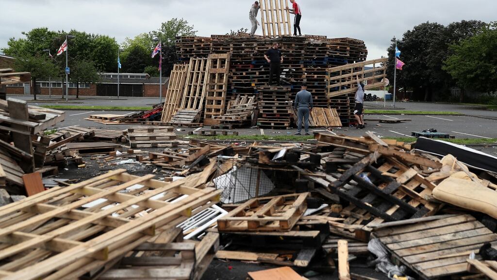 People add to the 11th night bonfire at Avoniel Leisure Centre in Belfast, which councillors agreed not to attempt to dismantle. Photograph: Brian Lawless/PA Wire.