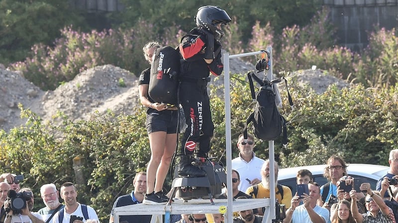 Chrysten, the wife of Franky Zapata, helps him with his pack as he prepares to try and fly across the Channel standing on a jet-powered ‘flyboard’. Photograph: AFP