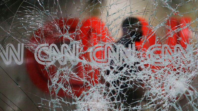 A security guard walks behind shattered glass at the CNN building  in Atlanta. Photograph: Brynn Anderson/AP