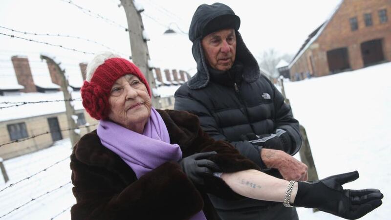 Rose Schindler (85) who is a survivor of the Auschwitz-Birkenau concentration camp, and her husand Max, who survived the nearby Plaszow camp, show their concentration camp tatoos while visiting the former Auschwitz concentration camp. Photograph: by Sean Gallup/Getty Images