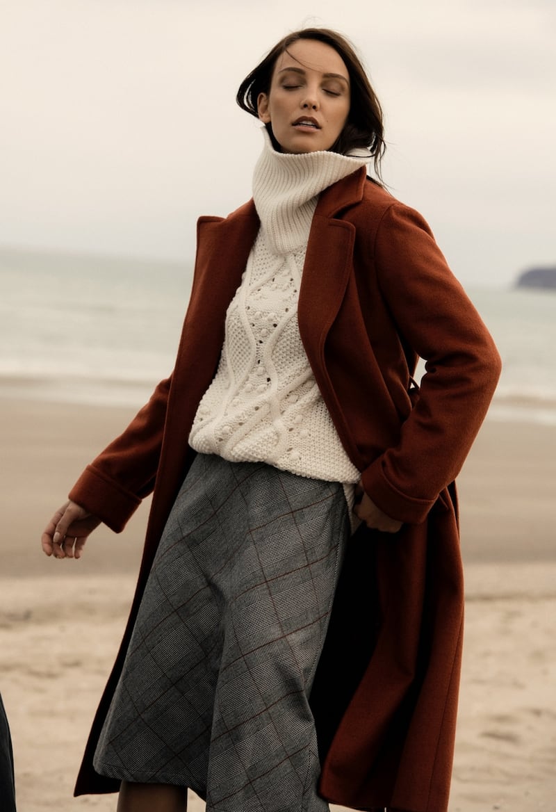 Rust wrap collar coat €199, pearl cable sweater €79.99, black skirt €69.95