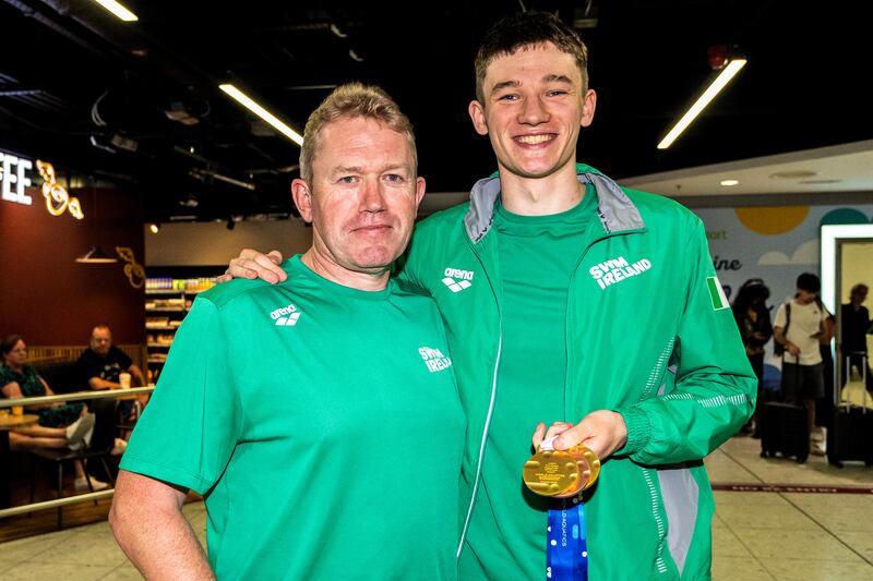John Shortt with his father Frank Shortt at Dublin Airport on Monday after returning home from the World Junior Swimming Championships in Romania, where he won two gold medals and a bronze. Photograph: Dan Clohessy/Inpho