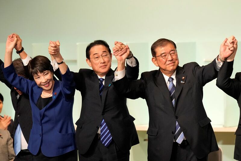 Shigeru Ishiba (right), Sanae Takaichi (left) and Japan's outgoing prime minister Fumio Kishida celebrate after Ishiba was elected as the new head of Japan's ruling party at the Liberal Democratic Party's leadership election in Tokyo. Photograph: Hiro Komae/AFP/Getty