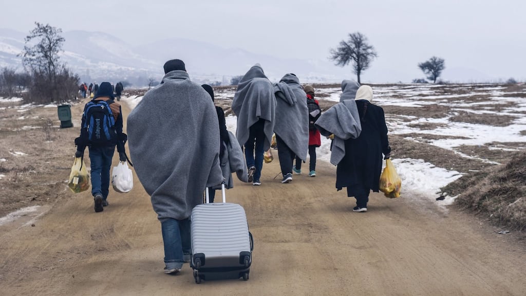 Migrants and refugees walk after crossing the Macedonian border into Serbia. A Belgian mayor has proposed banning male refugees from a swimming pool for a month after complaints from female bathers. Photograph: Armed Nimani/AFP/Getty Images.