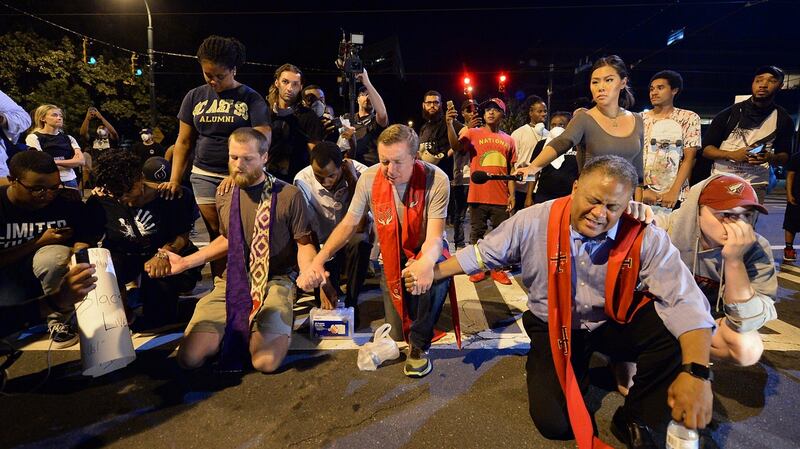 Clergy pray with protesters outside the Charlotte police department on Sunday. Photograph: Jeff Siner/The Charlotte Observer via AP