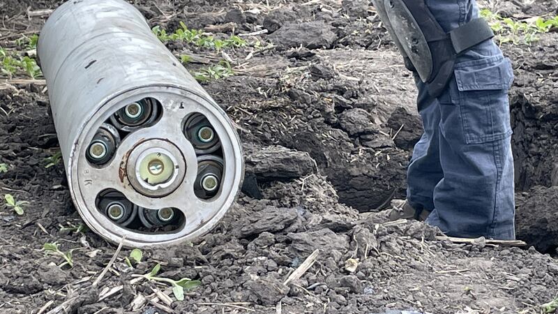 A Ukrainian sapper examines a Russian Uragan rocket with cluster munitions that landed in a field without exploding near Kharkiv airport.