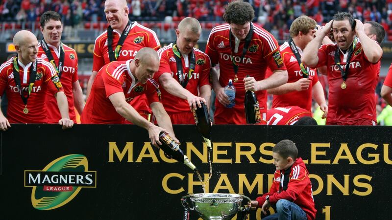 Munster players fill the cup as Jack Derbyshire looks on. Photo: Colm O’Neill/Inpho