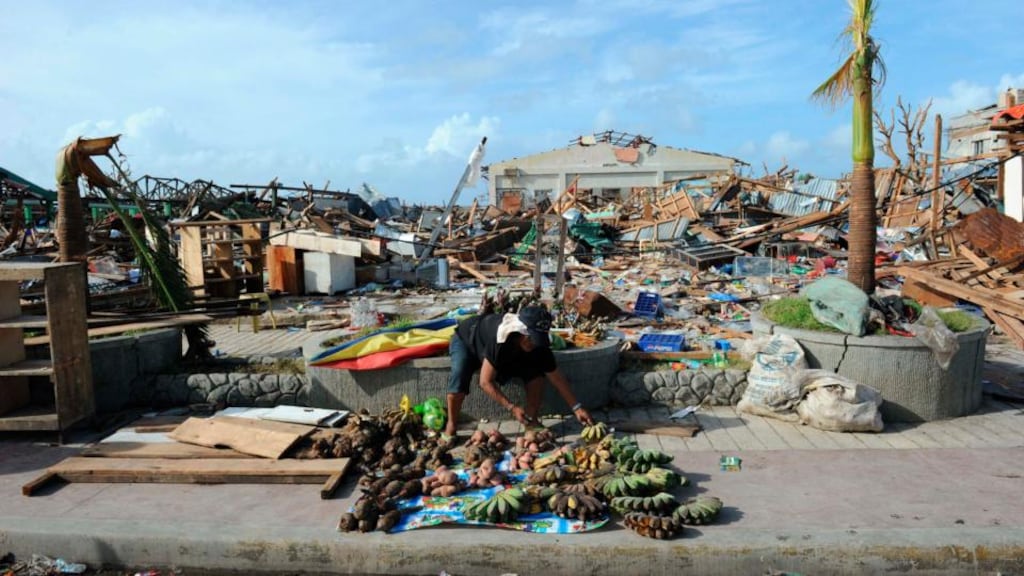 A man sells root crops and fruits next to a destroyed public market in Guiuan in the province of Eastern Samar, Philippines. Photograph: Ted Aljibe/Pool via The New York Times