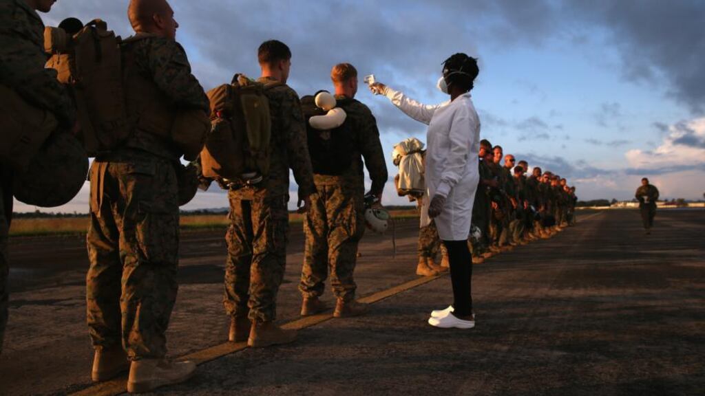 A health worker takes the temperature of US marines arriving to take part in Operation United Assistance near Monrovia, Liberia, yesterday. Photograph: John Moore/Getty Images