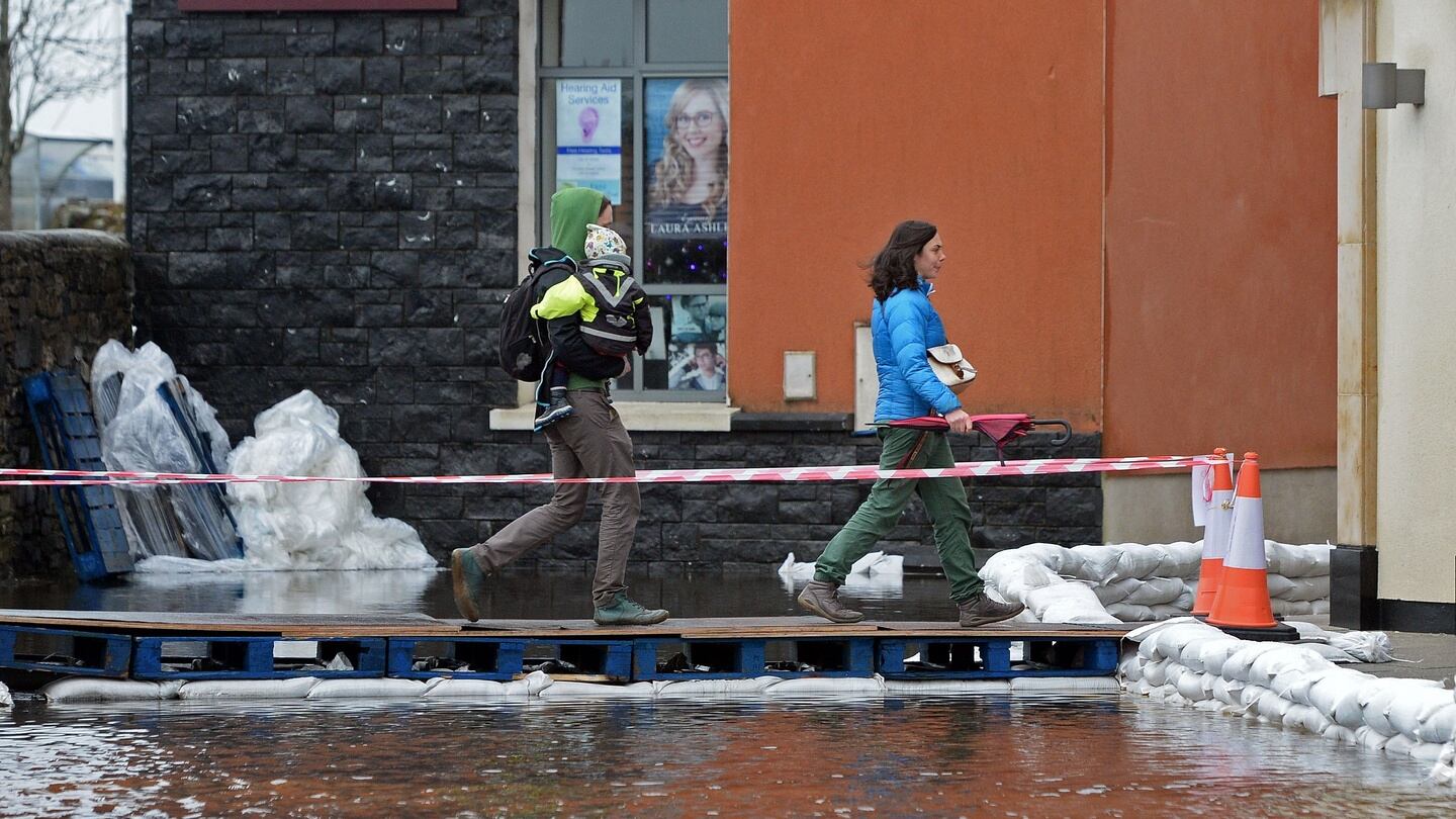 Pedestrians cross a hastily erected foot-bridge, over flood waters at Carrick-on-Shannon in Co Leitrim. Photograph: Eric Luke/The Irish Times