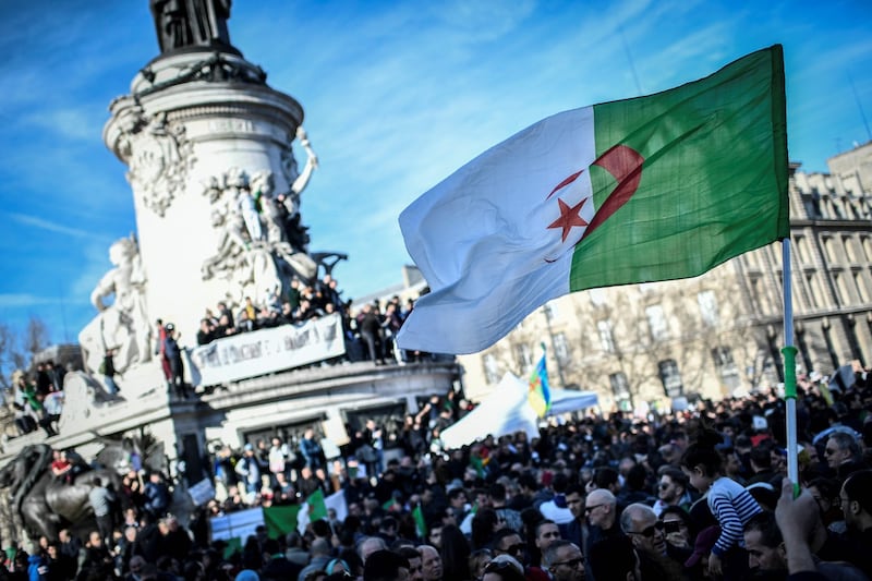 A protester holds up the Algerian flag during a rally against the Algerian president’s bid for a fifth term in office at the Place de la République in Paris. Photograph: Stephane de Sakutin/AFP/Getty