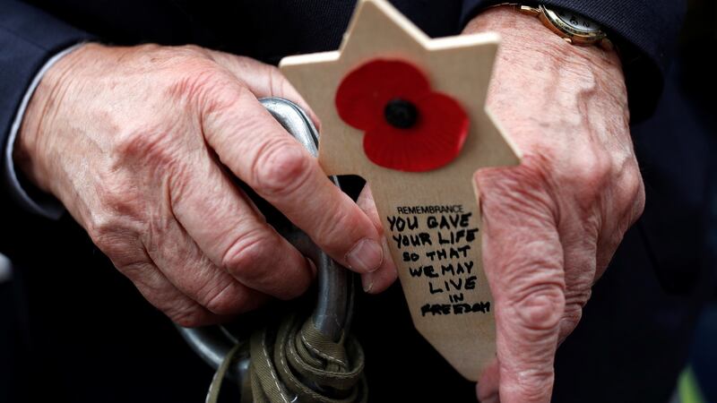 A D-Day veteran holds a remembrance cross as he attends a ceremony at Normandy American Cemetery and Memorial above Omaha Beach on June 4th. Photograph: Christian Hartmann/Reuters