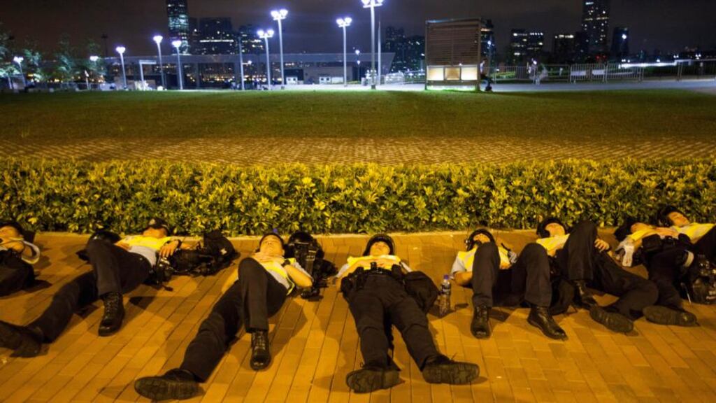 Policemen resting at the end of the first day of the mass civil disobedience campaign Occupy Central, in Hong Kong. Photograph: EPA