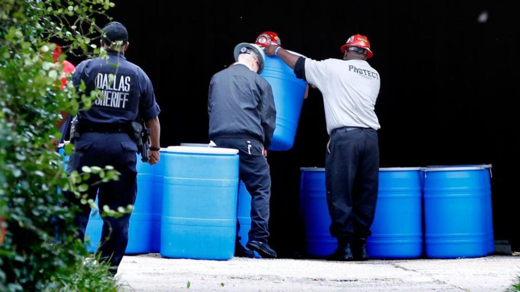 Hazardous-materials workers arrange waste removal barrels yesterday outside an apartment in Dallas where a second person diagnosed with the Ebola virus resides. Photograph: Mike Stone/Getty Images