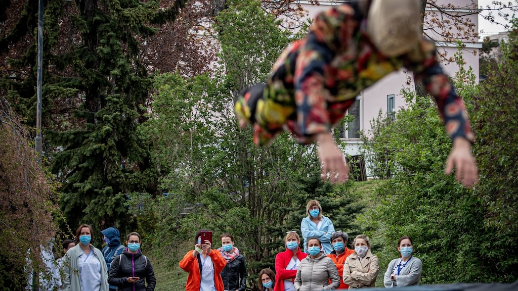 Health workers wearing protective face masks watch a member of the contemporary circus company Cirk La Putyka perform at the courtyard of a hospital in Prague, Czech Republic. Photograph: Martin Divisek/EPA