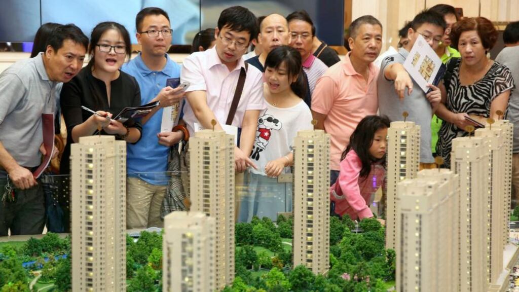 Customers look at a model of a new residential compound, at a showroom in Hangzhou, Zhejiang province. Photograph: Reuters