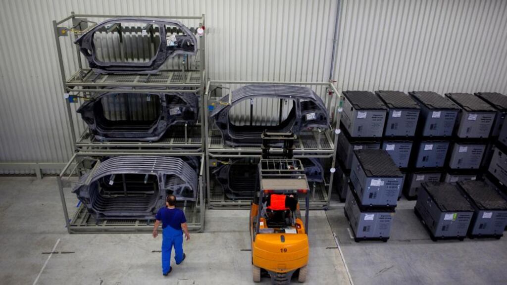 An employee stands beside a fork lift truck in front of side panel frames for BMW i3 battery-powered automobiles, manufactured by Bayerische Motoren Werke AG, at the company’s factory in Leipzig, Germany. Photograph: : Krisztian Bocsi/Bloomberg