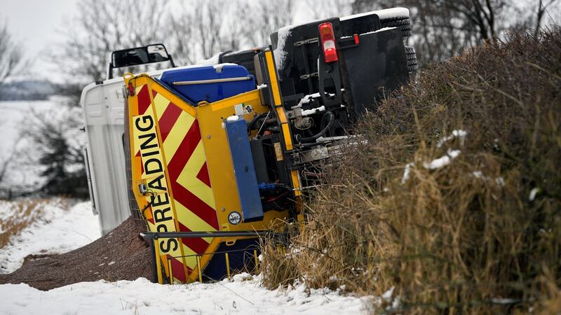 Men recover an overturned gritting lorry  in Balfron, Scotland. Photograph: Jeff J Mitchell/Getty Images