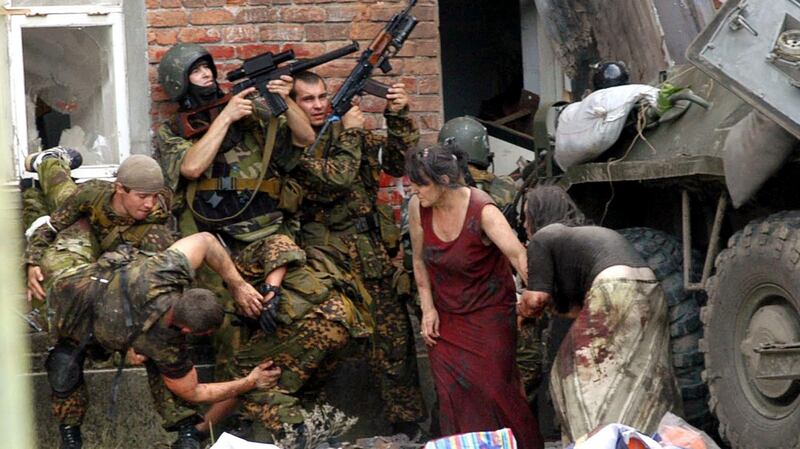 A Russian special police soldier carries an injured colleague as others take cover during the rescue operation at the school siege in Beslan in 2004. Photograph: Yuri Tutov/AFP/Getty