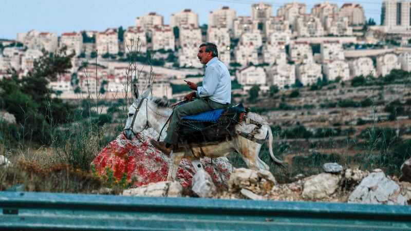 A Palestinian rides a donkey along a road with the Israeli settlement of Efrat, on the southern outskirts of Bethlehem in the occupied West Bank. Photograph: Ahmad Gharabli/AFP via Getty