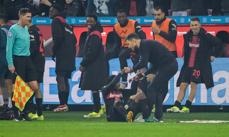 Bayer Leverkusen's Jeremie Frimpong is lifted by head coach Xabi Alonso and celebrated by team-mates after scoring the 3-0 goal against Bayern Munich. Photograph: Sascha Schuermann/Getty Images