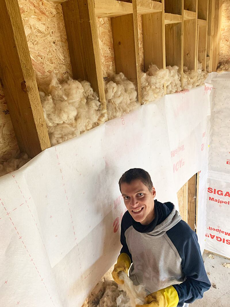 Thomas installing wool insulation
