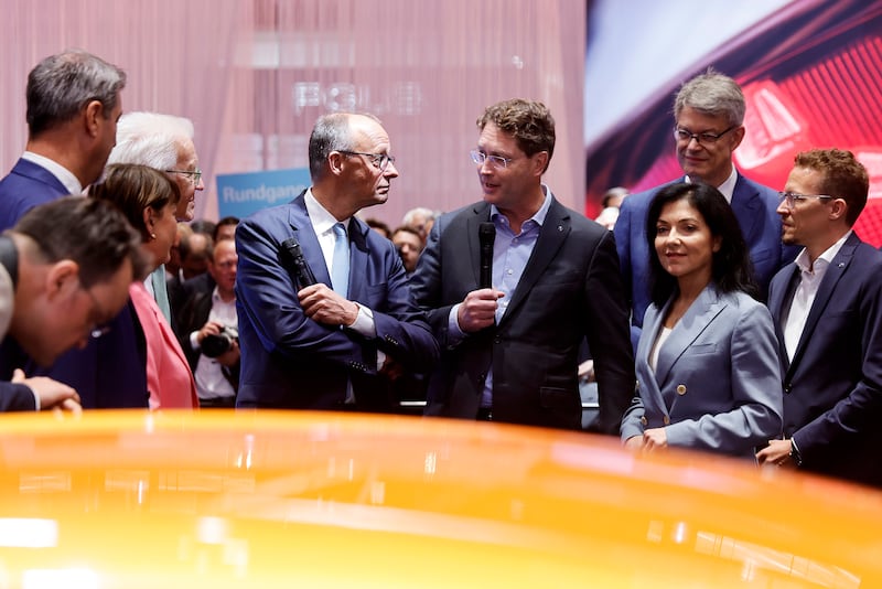 Ola Kaellenius (centre, right), chief executive of Mercedes Benz, talks to German Chancellor Friedrich Merz